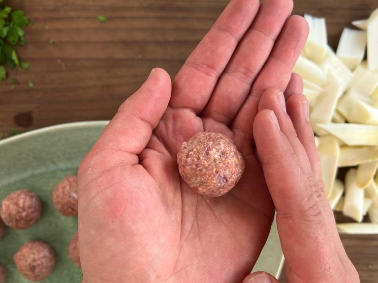 Peel and finely dice the shallot. In a large bowl, mix the minced meat with the shallot cubes, egg, breadcrumbs, mustard, lemon zest, salt and pepper and form small balls.