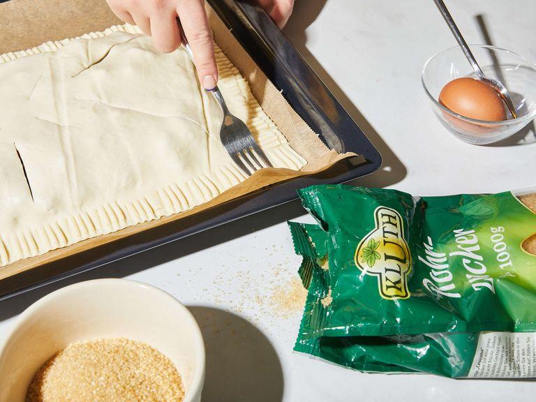 Carefully place the second piece of puff pastry over the top; rolling it back up to help you place it. Cut slits into the top puff pastry sheet, about three 7,5 cm/3-in. slits. Use a fork to seal the edges together tightly, then brush the top and edges with the beaten egg.