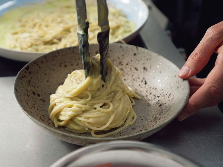 When pasta is done, drain and transfer to a large skillet. Add avocado sauce and toss until pasta is well coated. Heat up the pasta on low heat for approx. 2 min. Season with salt and pepper and divide onto plates.