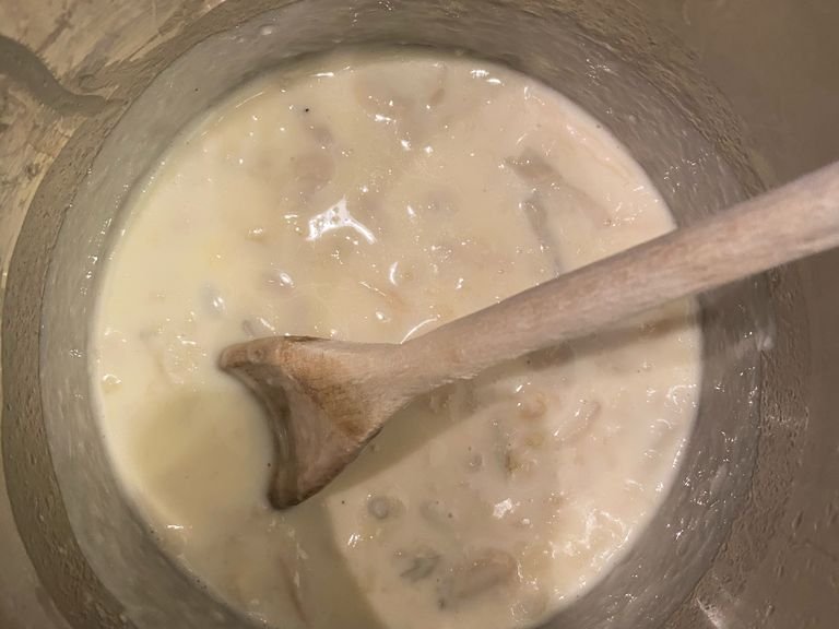 Nun die Milch und den in Scheiben geschnittenen Gorgonzolakäse in einen Stieltopf geben. Bei niedriger Hitze kochen, bis der Käse geschmolzen ist, dabei regelmäßig mit einem Löffel umrühren.