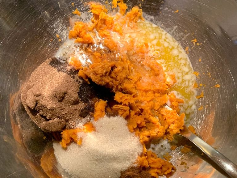 Add 1 bar of melted butter, white sugar, brown sugar, vanilla, ground cinnamon and lemon to the smashed sweet potatoes. Mix everything with a fork.