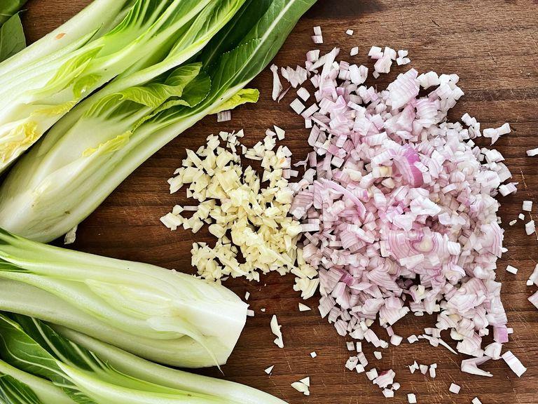 Peel and finely dice the garlic and shallots. Quarter bok choy. Cook the soba noodles in boiling salted water until al dente, then drain and rinse with cold water.