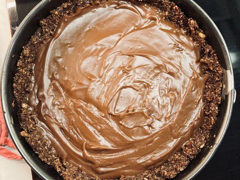 Den Pudding recht zügig auf dem leicht ausgekühlten Boden verteilen und vollständig erkalten lassen, bevor der Kuchen angeschnitten wird.