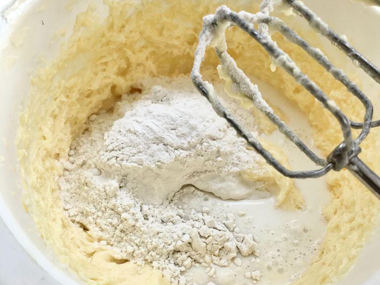 Mix baking powder with flour. Start adding flour and milk to dough. And continue mixing.