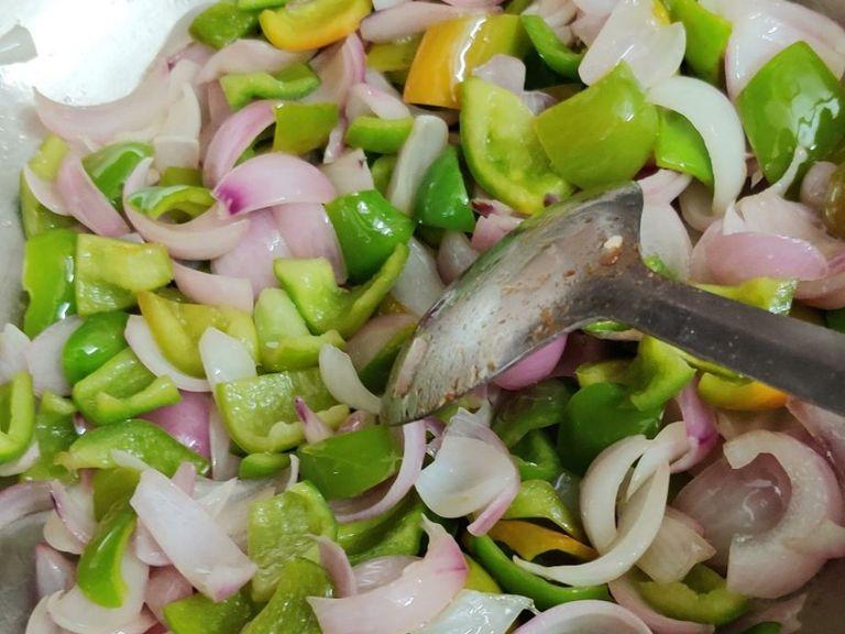 Add 2 tbsp oil to kadai and after 1 minute add capsicum and onion cubes. Fry for 3-4 minutes.