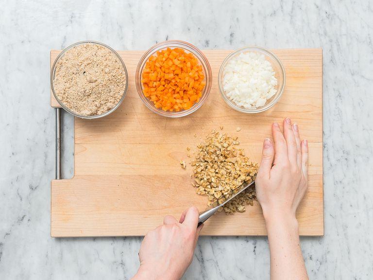 Preheat oven to 190°C/375°F. Grease loaf pan and dust with breadcrumbs. Peel and finely dice some of  the onions and carrot. Finely chop walnuts. Crumble white bread. Add ground flaxseed and water to a small bowl and stir to combine.
