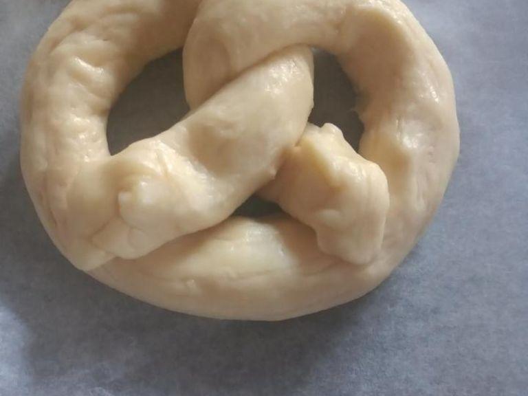 Shape into pretzels by making a horseshoe facing away from you, twisting the 2 sides together and placing the ends on the part nearest to you.