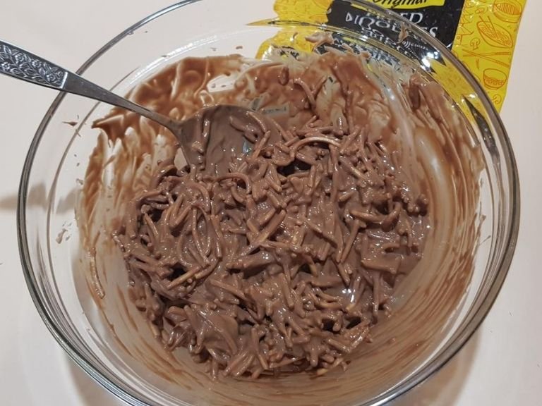 Add all of the fried noodles to the bowl. Try to coat them all in chocolate & peanut butter mixture.