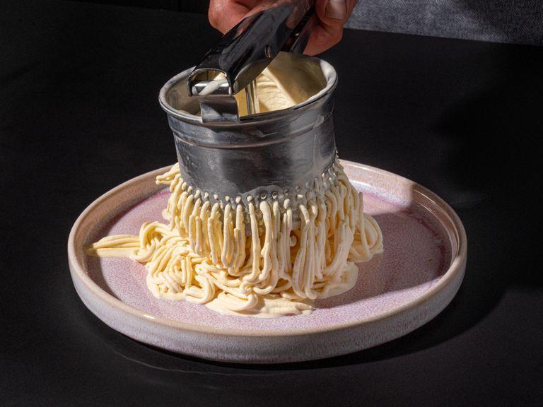 Scoop whipped cream on each of the plates. Don’t spread it out. Instead, pile it high onto the plates. For each serving, fill your potato ricer with 5.3 oz of vanilla ice cream. Push the ice cream on top of the whipped cream. It should look like real spaghetti.
