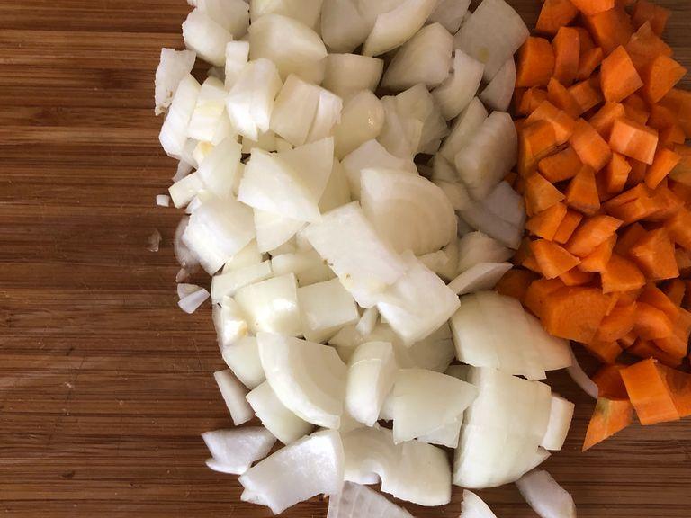 Karotten und Zwiebeln in Würfel kleinschneiden