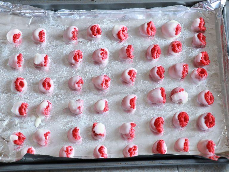 Using a toothpick or your hands, dip the raspberries into the yogurt and place onto a tray.
