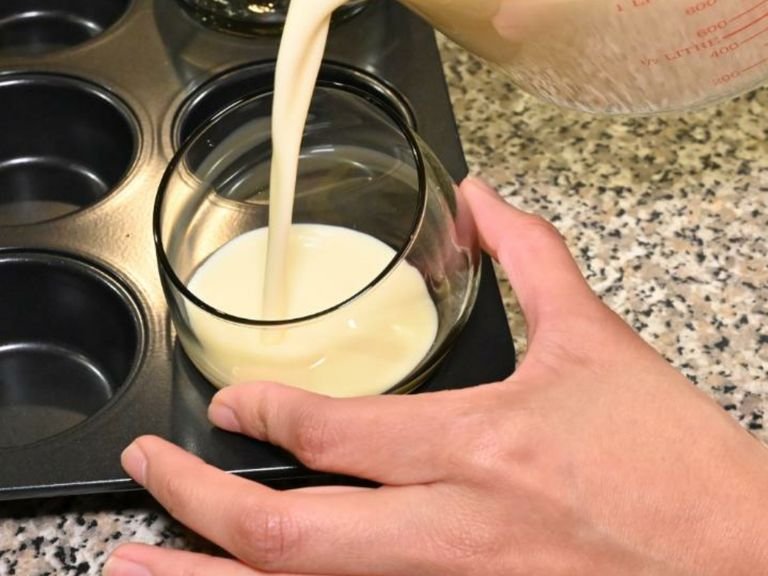 Verwende eine Muffinform, um die Dessertgläser darin zu platzieren. Stelle die Gläser leicht diagonal in die Muffinform und halte sie fest, während du vorsichtig die Crememischung hineingießt. So entsteht die besondere Schichtung.