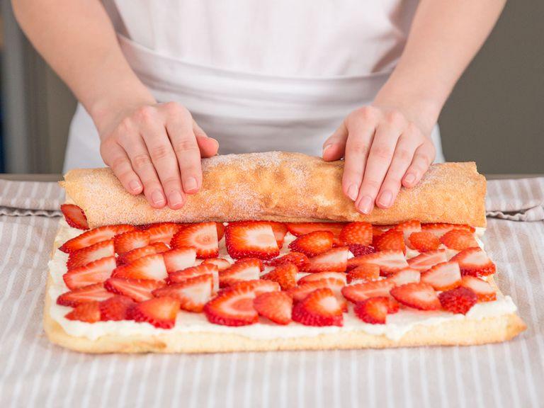 Make sure your cake has cooled down before you start this step. Spread approx. two-thirds of cream filling on top cake, followed by an even layer of strawberries. Then, roll cake forward using towel.