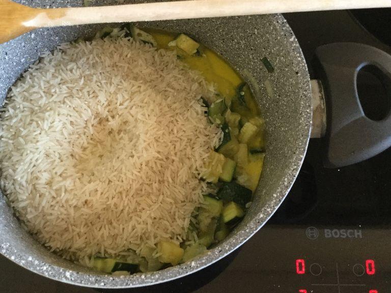 When the zucchinis are transparent, add the rice and milk