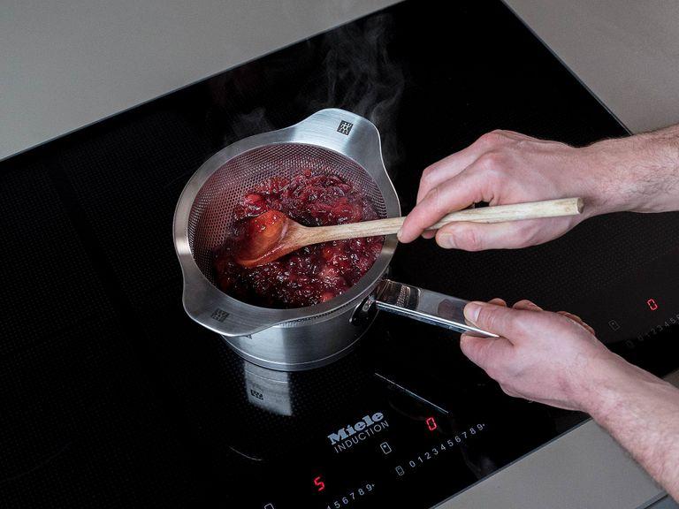 Strain cranberry sauce through a sieve, using a wooden spoon to press the juice out of the cranberries. Remove from heat.