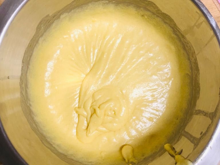 Nun wird die Butter auf dem Herd bei kleiner Hitze zerlassen und dann abgekühlt. Jetzt wird sie mit der Vollmilch, dem Zitronensaft und den Eiern in die Schüssel, wo bereits die trockenen Zutaten sind, gegeben und zu einem glatten Teig verrührt.