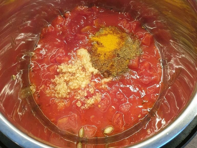 Add the canned tomatoes (including water), garlic, ginger, and dry spices to the Instant Pot and stir.
