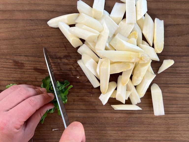 Peel the asparagus and cut diagonally into pieces approx. 2 cm long. Grate the zest of half a lemon. Finely chop the parsley and set aside.