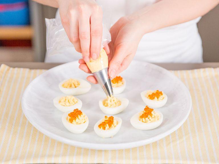 Transfer egg mixture to a piping bag and pipe into the halved egg whites. Top each egg with trout caviar and garnish with garden cress. Enjoy!