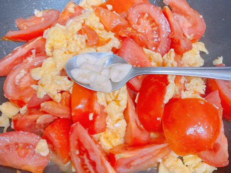 Heat the rest of the oil and put in the tomatoes. Add sugar (feel free to add more if you prefer it to be sweeter) and then fry for 3 minutes until the juice gets soaked out. Then add the scrambled egg. Sir to mix well. Add the garlic on top and put on the lid and let it sit for 1 minute. It’s done! Bon appetite!
