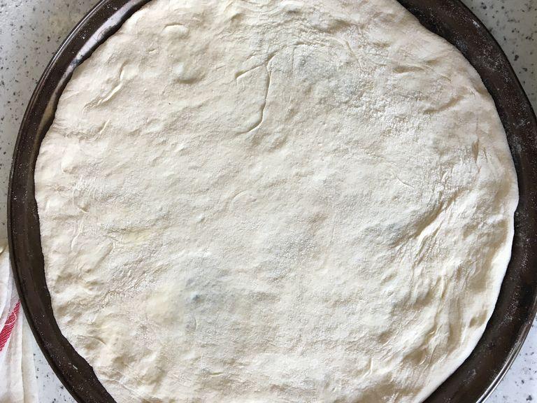 When the dough pieces have finished their second rise, carefully flatten one of them with your hands and help of its own weight. Adjust the dough over your prepared baking sheet onto a roughly 25-28 cm circle. Bake for 4-6 min. keep an eye on it to make sure it won’t be over-baked. Repeat the same procedure for second dough. Before baking, sprinkle Za’tar on top and drizzle a generous amount of olive oil. Arrange onion slices and part of the olives over and bake for 6-8 min.