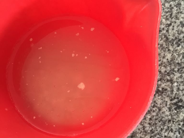 in a measuring cup combine warm water, yeast and sugar. Stir.