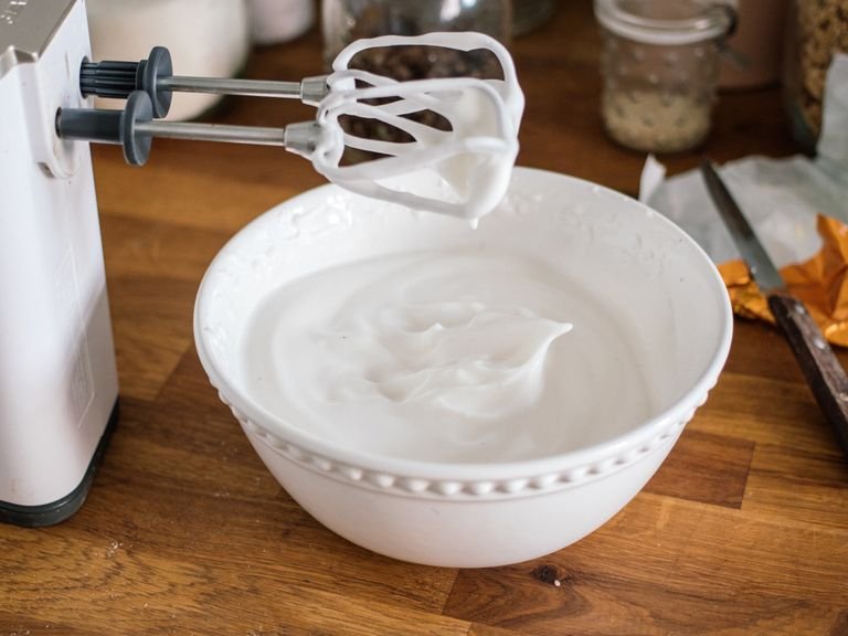 Place a fine sieve over a bowl and drain the canned chickpeas. The reserved liquid in the bowl is aquafaba. You should have approx. 100 ml (1/2 cup) aquafaba per 400 g/14 oz. can of chickpeas. Add aquafaba, whipped cream stabilizer, vanilla extract, and salt to a stand mixer with whisks, and whisk for approx. 10 min., or until the mixture is stiff. You can also use a hand mixer for this. The volume should increase significantly.
