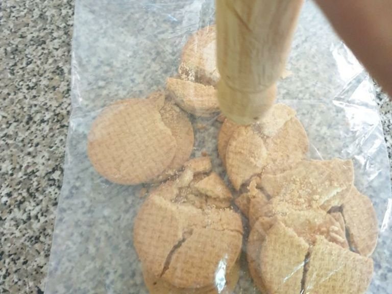 Crush the biscuits in a freezer bag, using a rolling pin.