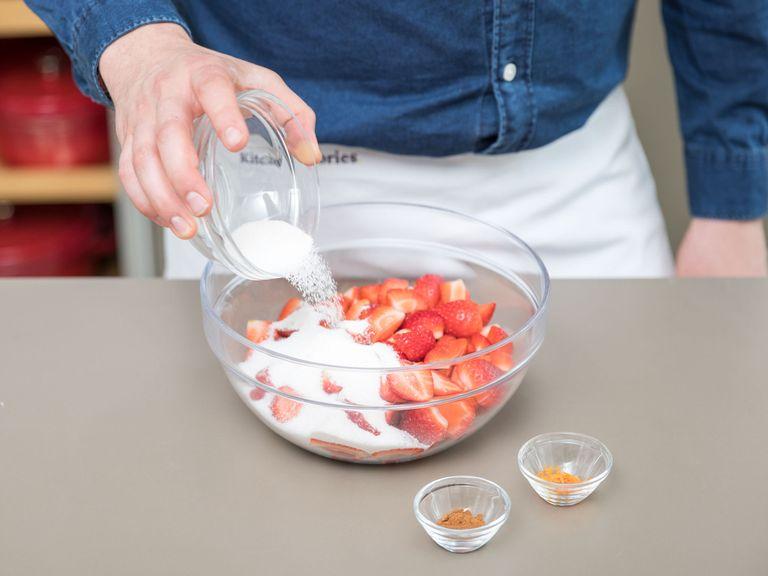 Die Tarteform einfetten und den Ofen auf 200°C vorheizen. Erdbeeren halbieren. Erdbeeren mit dem restlichen Mehl, Zucker, Zimt und Orangenschale vermischen.