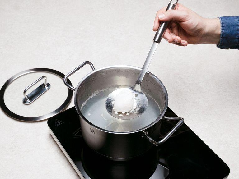 Fill a small pot with water and bring to a boil. Poach eggs in the pot with a dash of white wine vinegar until set but runny in the center, approx. 4 min. Remove with a slotted spoon and gently dab with paper towels to remove excess water.