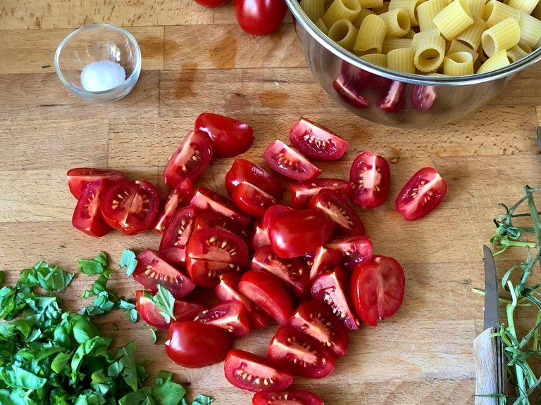 Tomaten in mundgerechte Stücke schneiden, Basilikum grob hacken. Nudeln portionieren, etwa 180 Gramm für 2 Portionen. Die auf der Packung angegebene Kochzeit verifizieren.