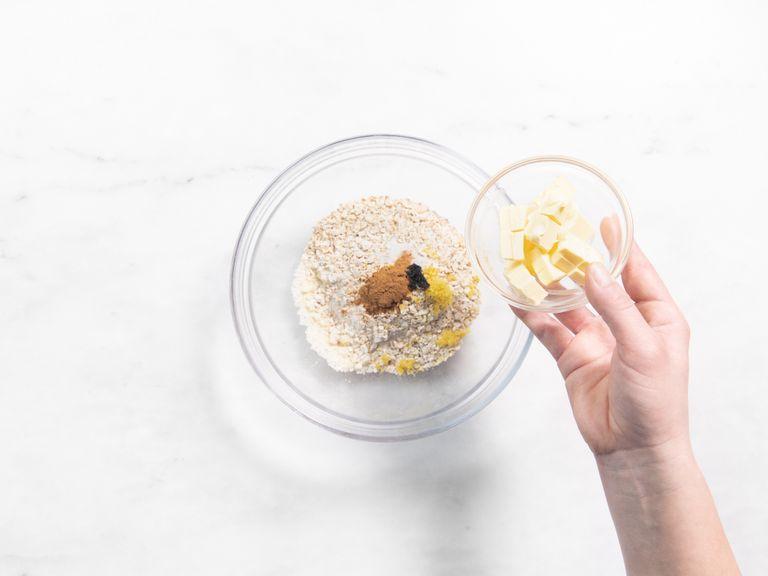 Add remaining sugar and cinnamon to a bowl with ground almonds, flour, rolled oats, lemon zest, vanilla bean seeds, butter, and a pinch of salt. Use your hands to mix everything together until the mixture resembles chunky breadcrumbs.