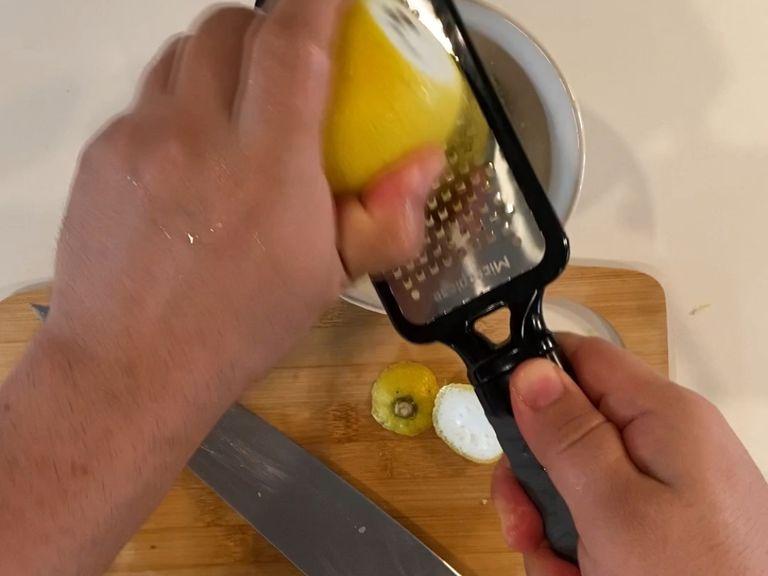 Prep some lemon zest using grater into a bowl with feta cheese