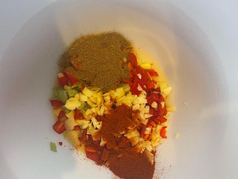 Add the chillies, celery, garlic and ginger into a mixing bowl once in the bowl add your 2tsp of Hot paprika, Cumin Powder and 1 pinch of salt and mix it all together. 
