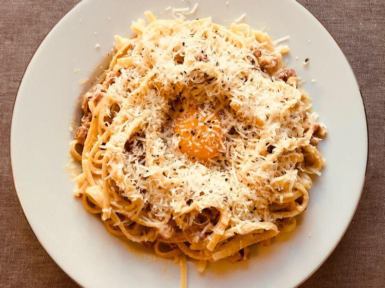 Mix the spaghetti and the sause, add a cavity at the top. Sprinkle on some more cheese, add the yellow part of the egg. Add more cheese, and last of all: pepper.