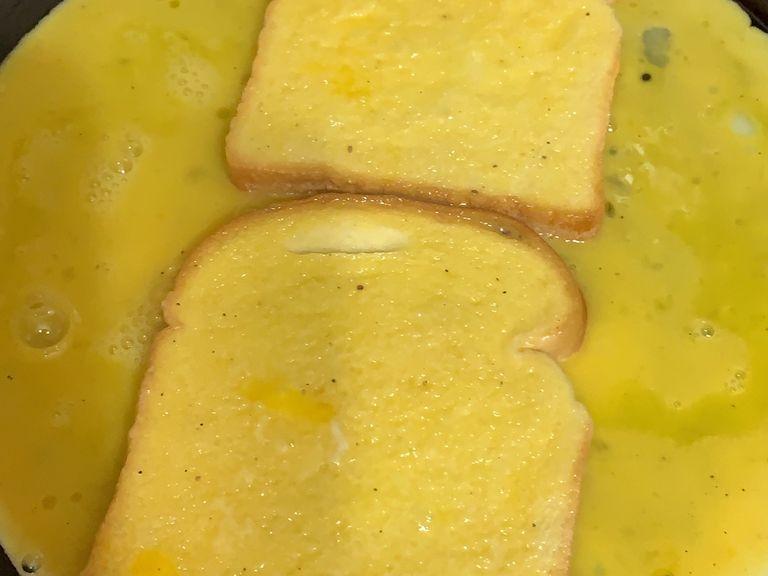 As the pan heats up, lower the heat and pour in the eggs and then put the toast above the eggs vertically as seen in the pic attached. Quickly dip the toast on both sides so they can have some of the eggs and let it rest. 