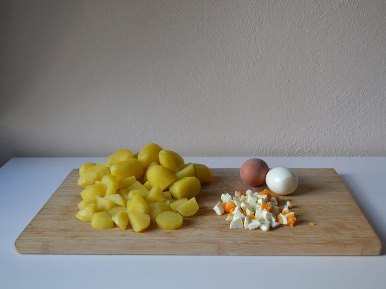 Peel and finely dice cold eggs. Cut potatoes in large chunks (to preference). Put them in a large bowl, together with the pickles and apple pieces.