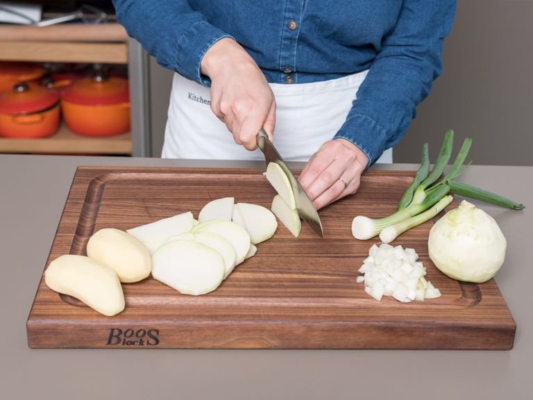 Preheat oven to 200°C/400°F convection heat. Peel kohlrabi and potatoes and thinly slice. Finely dice onion and slice spring onions into fine rings. In a large bowl, mix kefir, heavy cream, and eggs, and season with nutmeg, salt, and pepper.