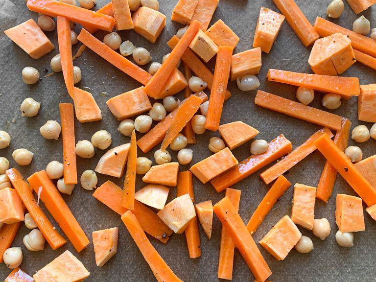 Preheat the oven to 200ºC/390ºF. Add chickpeas, carrot, and sweet potatoes to a parchment-lined baking sheet, drizzle with oil, season with salt and pepper. Roast for approx. 15 - 20 min. Remove and let cool.