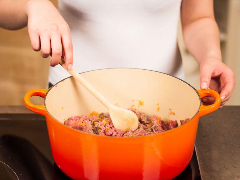 Heat some vegetable oil in a large frying pan and sauté onions, garlic, and carrots. Add ground beef and cook over medium-high heat until meat is browned, approx. 6 - 10 min. While cooking, break into pieces with a cooking spoon. Season with salt and pepper.