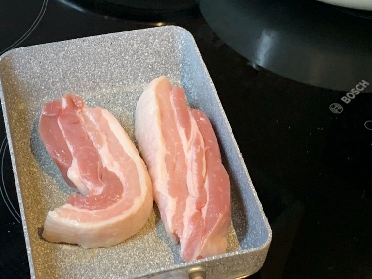 Place the pork belly slices onto a heated frying pan without oil.