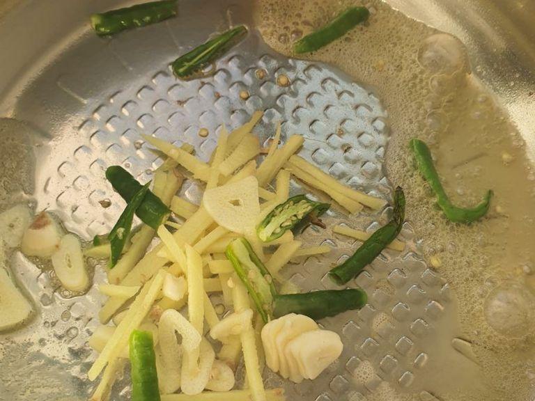To a pan add butter, sliced ginger, garlic and green chillies and saute till they turn golden.