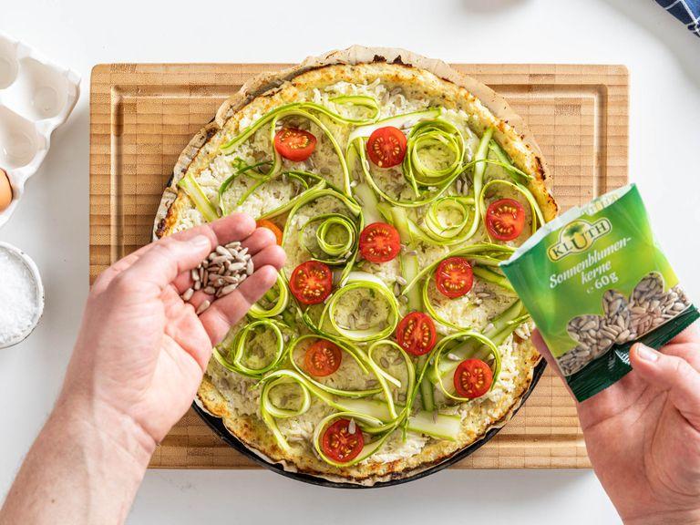 Spread cheese sauce over the pizza base. Now arrange shaved asparagus on top, add halved cherry tomatoes and sprinkle with sunflower seeds. Return to the oven and bake for approx. 15 min. more. Garnish with parsley and flaky sea salt before serving and enjoy!