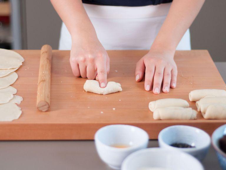 Make an indentation in the center of each roll with your finger. Wrap the dough into a circle with the indentation at its center. Shape into a smooth ball and roll this ball into a thin, round disc.