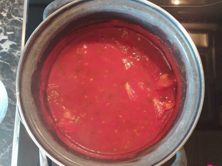 250ml Wasser aufkochen, Gemüsebrühe, Tomateninneres und Tomatenmark einrühren. Petersilie und Oregano hinzufügen. Ca. 2-4 Minuten aufkochen.