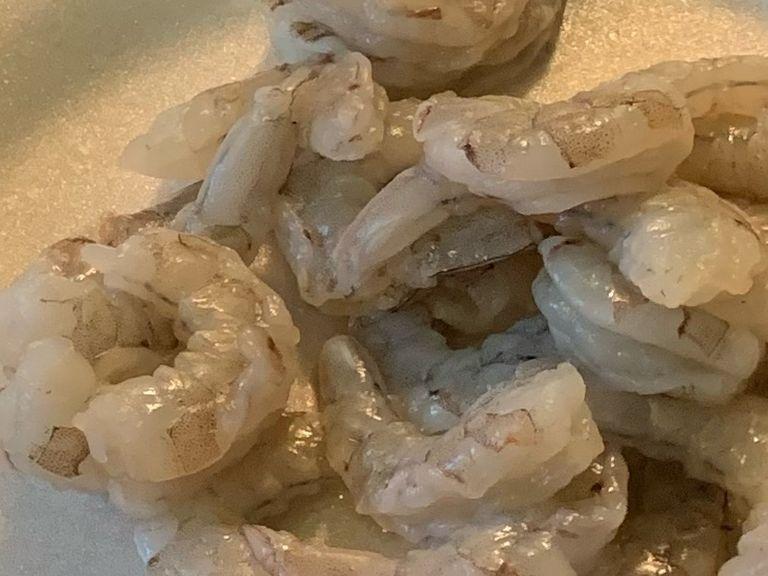 If you have frozen shrimp be sure to defrost them in cold water before peeling them. Once the shrimp are unthawed remove any excess veins, shells, and tails. Set them aside once completed.