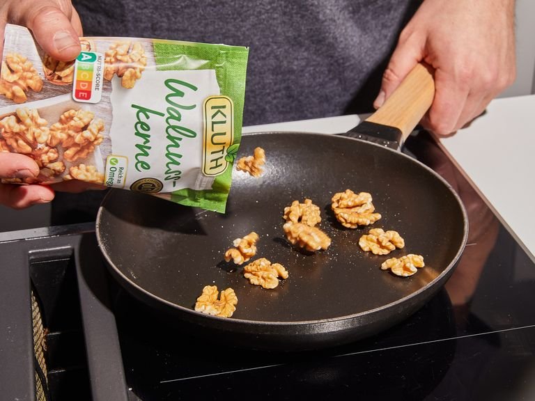 In a frying pan, toast walnuts over medium heat, tossing often until browned.