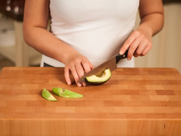 Avocado vierteln und entkernen. Vorsichtig die Schale entfernen und Avocado in Streifen schneiden. Mit Pflanzenöl bepinseln.