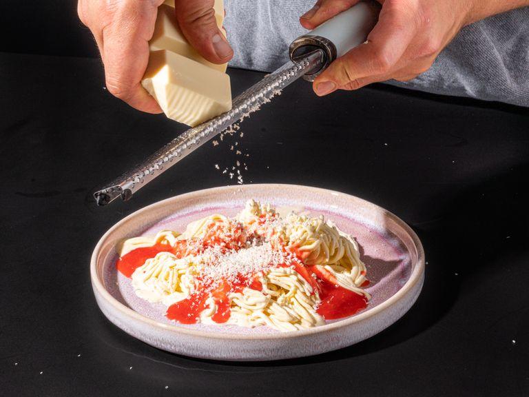 Die Erdbeersoße wie Tomatensoße über der Eiscreme verteilen. Die weiße Schokolade reiben und das Spaghettieis mit dem "Parmesan" garnieren. Guten Appetit!
