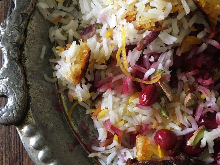 To serve the dish, mix 2 tbsp of rice with remaining saffron. Distribute half of the white rice onto an appropriate plate. Arrange a layer of sour cherries, some of almond-pistachio, part of the zest over and a tbsp of saffrony rice. Then repeat the whole process one more time. Set the crispy tah-dig pieces around the plate. Enjoy!